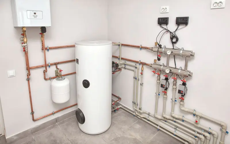 Salle technique avec ballon d'eau chaude et nourrice de distribution
